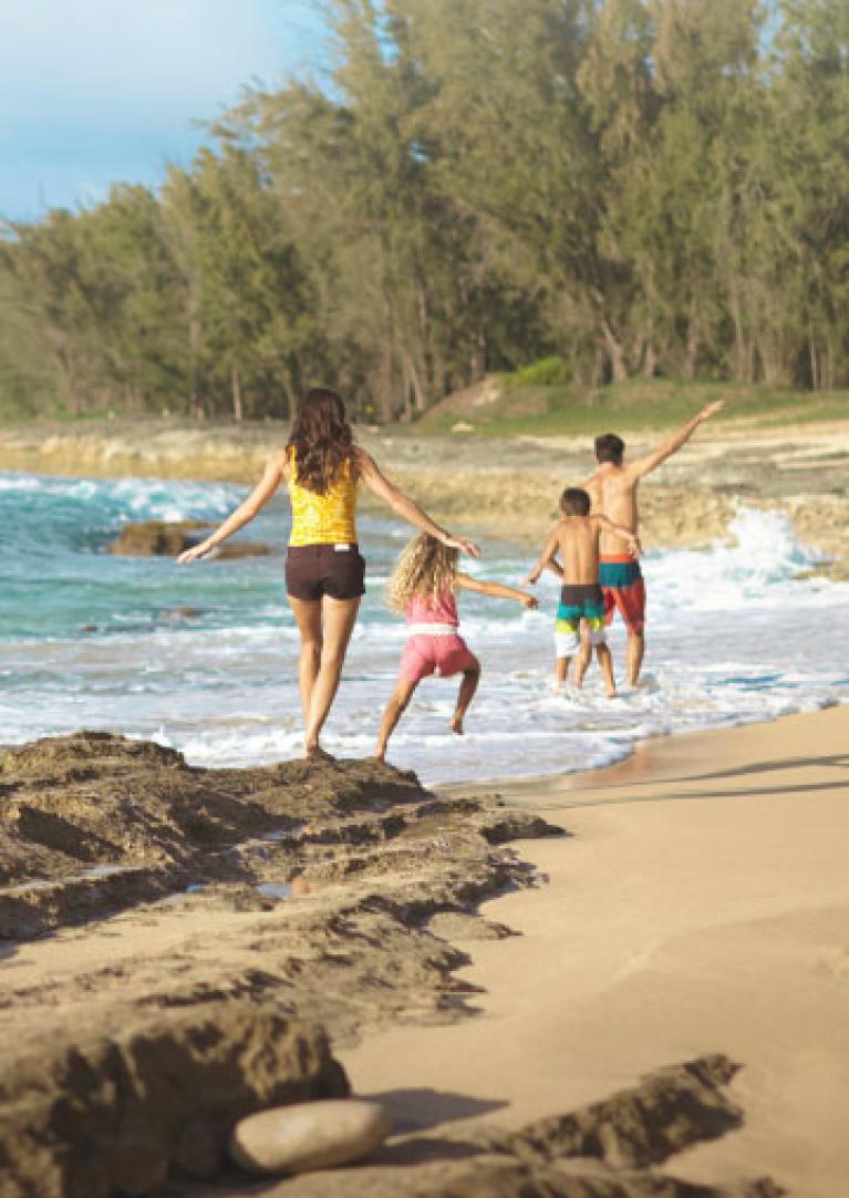 Family of four walking on beach